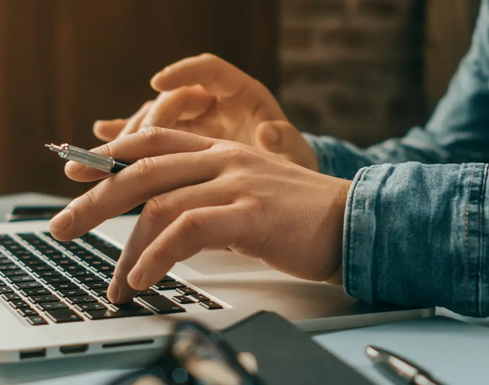 Hands typing on a laptop keyboard, representing modern workplace productivity tools.