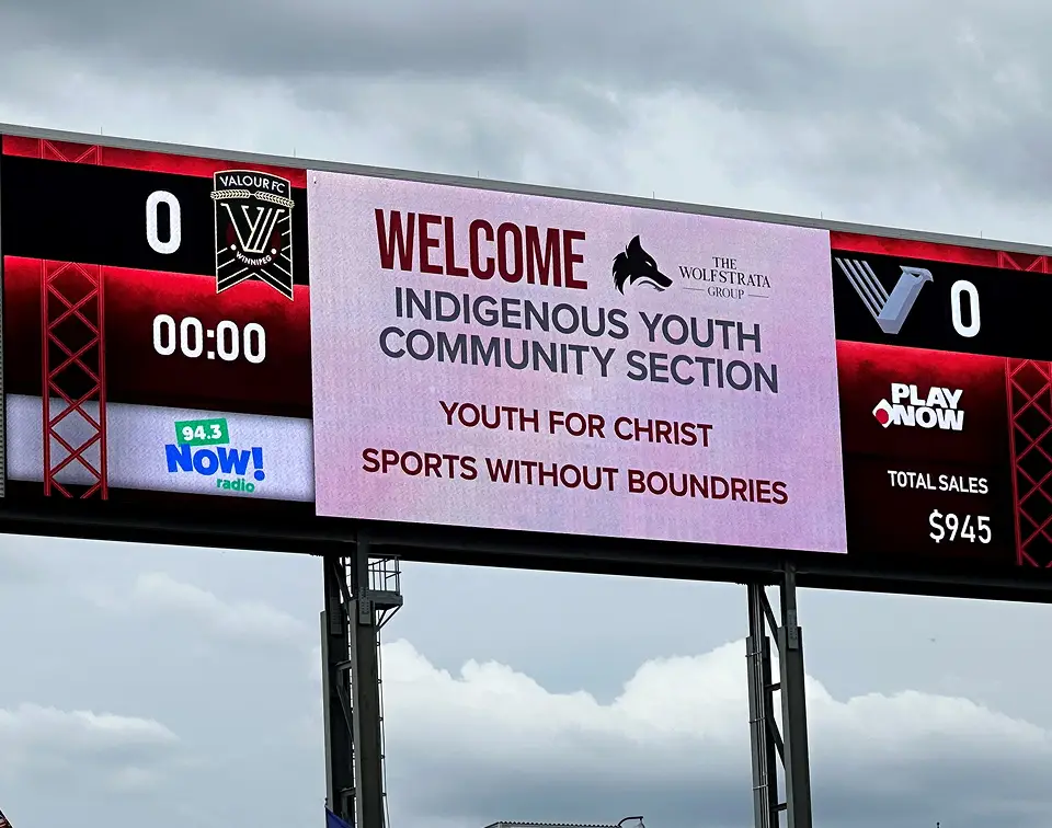 Scoreboard at Winnipeg Valour FC soccer game showing WolfStrata's community sponsorship.