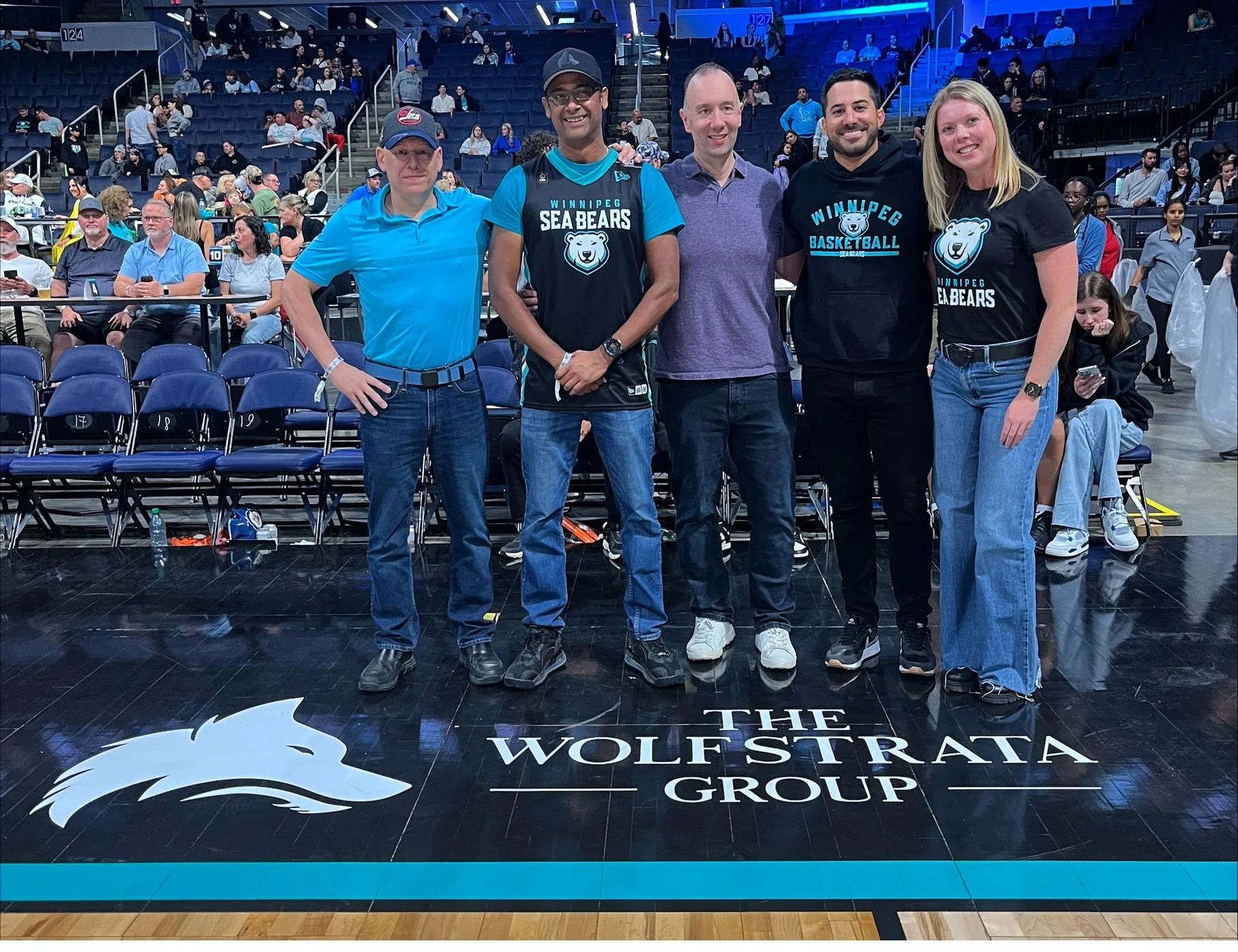 WolfStrata team at Winnipeg Sea Bears game celebrating sponsorship of local basketball team.